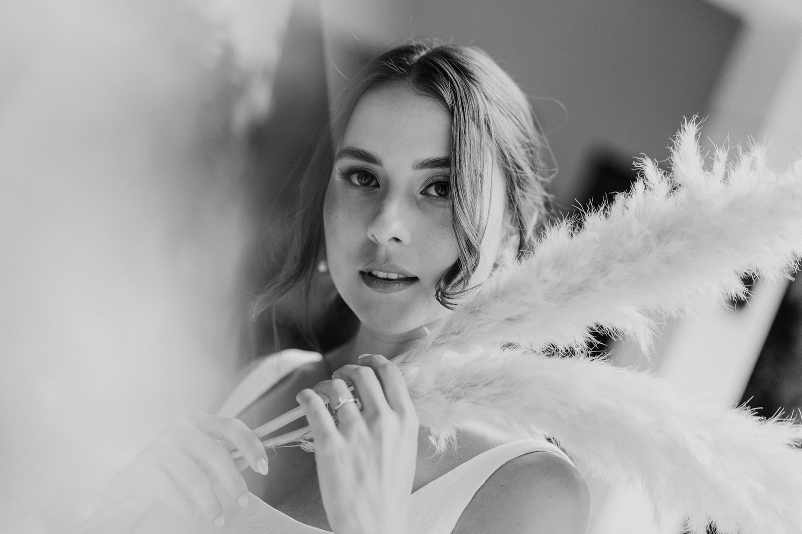 Bride framed through haze holding pampas